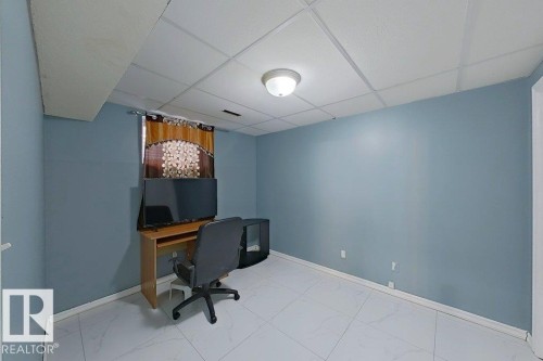 The room features light blue walls, white tiled flooring, and a drop ceiling with recessed lighting - 3347 24 Avenue, Edmonton, AB - Indoor