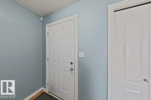 Entryway featuring a paneled door and light blue walls - 3347 24 Avenue, Edmonton, AB - Indoor Photo Showing Other Room