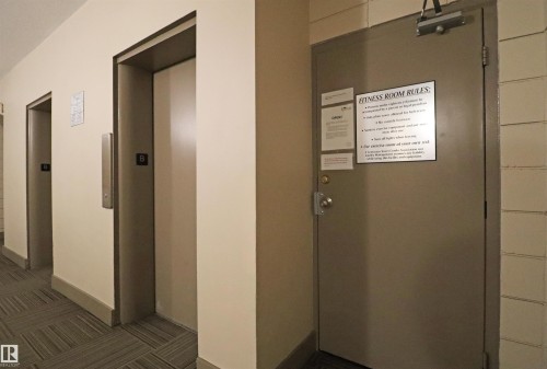 Corridor featuring two elevators and a fitness room door with signage - 901 10160 116 Street, Edmonton, AB - Indoor Photo Showing Other Room