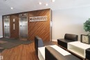 Lobby with two stainless steel elevators, wood-finish accent wall, recessed lighting, and wood-finish flooring - 901 10160 116 Street, Edmonton, AB  - Indoor 
