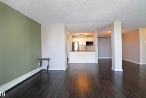 Expansive open-concept living area featuring dark wood-finish flooring - 901 10160 116 Street, Edmonton, AB - Indoor