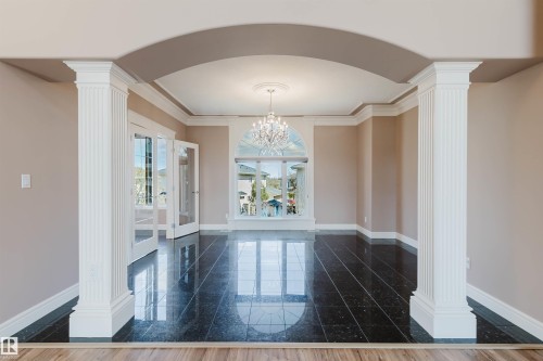 Spacious room featuring dark polished tile flooring and an arched entryway - 2408 Tegler Green, Edmonton, AB - Indoor Photo Showing Other Room