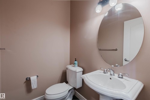 Pedestal sink with chrome fixtures and an oval vanity mirror - 2408 Tegler Green, Edmonton, AB - Indoor Photo Showing Bathroom