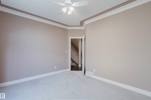 Spacious room featuring light neutral wall tones, plush carpet flooring, and a ceiling fan with integrated lighting - 2408 Tegler Green, Edmonton, AB - Indoor Photo Showing Other Room