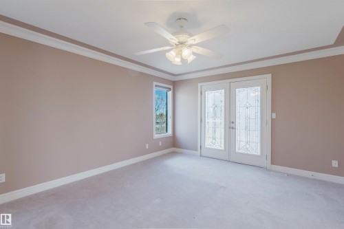 Room featuring double doors with decorative glass panels, a single window, and light-colored carpeting - 2408 Tegler Green, Edmonton, AB - Indoor Photo Showing Other Room