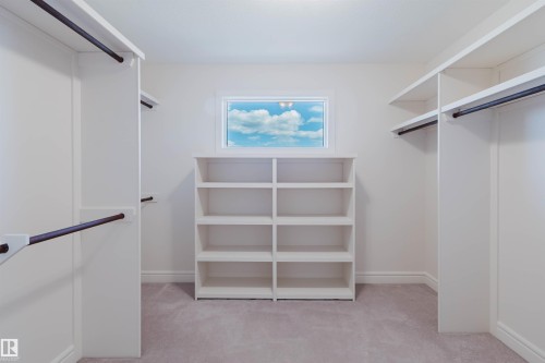 Walk-in closet with built-in shelving, clothing rods, and a window - 2408 Tegler Green, Edmonton, AB - Indoor With Storage