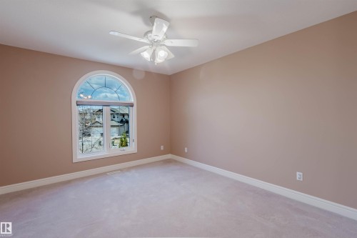 Arch-top window with white trim, light-colored walls, and a ceiling fan with integrated lighting - 2408 Tegler Green, Edmonton, AB - Indoor Photo Showing Other Room