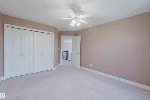 Carpeted room with a ceiling fan, white trim, and bi-fold closet doors - 2408 Tegler Green, Edmonton, AB - Indoor Photo Showing Other Room
