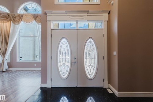 Entryway featuring double doors with leaded glass oval inserts, transom window, and a grand decorative frame - 2408 Tegler Green, Edmonton, AB - Indoor Photo Showing Other Room