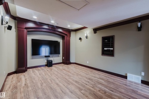 Recessed entertainment niche with ornate wood trim and columns, featuring a wall-mounted display - 2408 Tegler Green, Edmonton, AB - Indoor