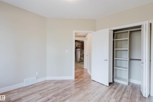 Room featuring wood-finish flooring, light neutral wall paint, and white baseboards - 2408 Tegler Green, Edmonton, AB - Indoor Photo Showing Other Room