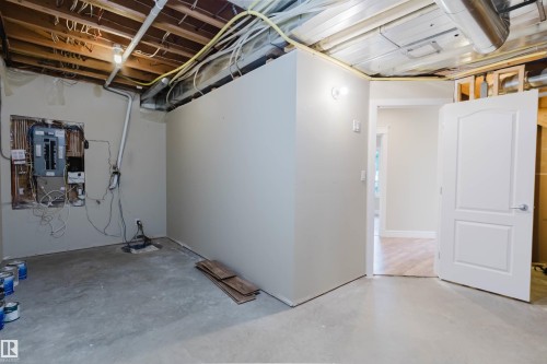 Unfinished basement space featuring exposed joists, visible wiring, and a concrete floor - 2408 Tegler Green, Edmonton, AB - Indoor Photo Showing Basement