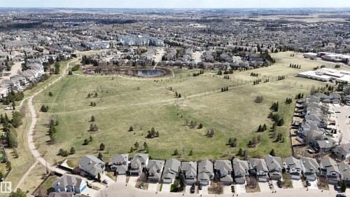 Expansive green space featuring a large pond, mature evergreen trees, and paved walking paths - 2408 Tegler Green, Edmonton, AB - Outdoor With View