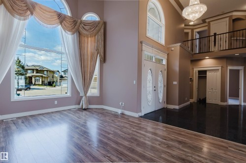 Grand entry foyer with double doors featuring decorative glass inserts and an overhead transom window - 2408 Tegler Green, Edmonton, AB - Indoor Photo Showing Other Room