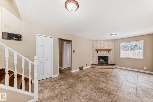 Wood burning fireplace with a gas lighter. Fireplace Stone is TYNDALL Stone from Manitoba. - 38 Lancaster Crescent, St. Albert, AB - Indoor With Fireplace