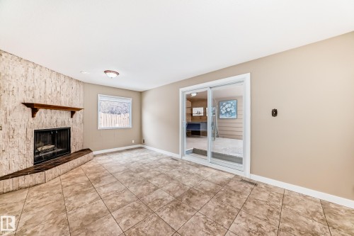 Exit to a permanent deck addition open on one side.. - 38 Lancaster Crescent, St. Albert, AB - Indoor With Fireplace