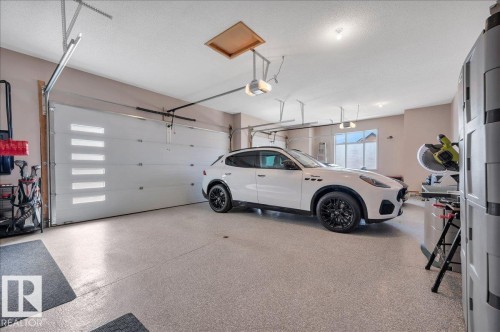 OVERSIZED TRIPLE GARAGE WITH EPOXY FLOOR, DRYWALLED, PAINTED, TEXTURED CEILING, FLOOR DRAIN, GAS HEATER, LEVEL 2 VEHICLE CHARGER AND HEIGHT FOR VEHICLE LIFTS - 314 Weaver Point(E), Edmonton, AB - Indoor Photo Showing Garage