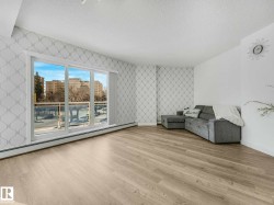 Living area featuring light wood-finish flooring and a full-width sliding glass door - 