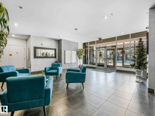 Lobby area featuring large format tile flooring, a textured accent wall, and a full-height glass entry system - 305 10504 99 Avenue, Edmonton, AB - Indoor