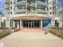 Building exterior featuring multiple balconies with glass railings, a curved entrance canopy, large storefront windows, and a stone facade - 305 10504 99 Avenue, Edmonton, AB  - Outdoor With Balcony 