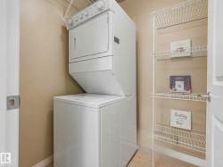 Dedicated laundry area featuring a stacked washer and dryer unit, wire shelving, and neutral wall paint - 