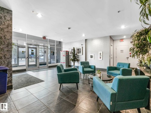 Lobby entrance featuring large format tile flooring, full-height glass entry doors, and a textured accent wall - 305 10504 99 Avenue, Edmonton, AB - Indoor