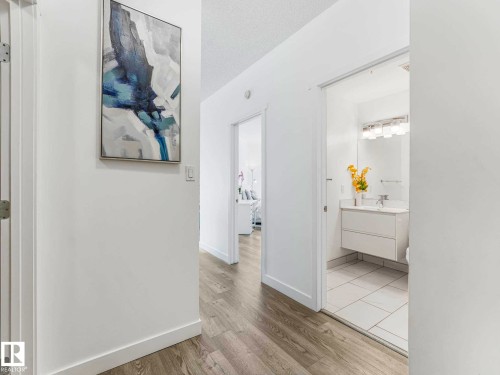 Hallway with wood-finish flooring and white baseboards - 305 10504 99 Avenue, Edmonton, AB - Indoor