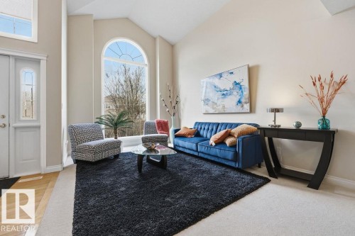 Vaulted ceiling entry foyer featuring an arched window, transom window, and a paneled entry door with decorative glass - 11551 14 Avenue, Edmonton, AB - Indoor Photo Showing Living Room