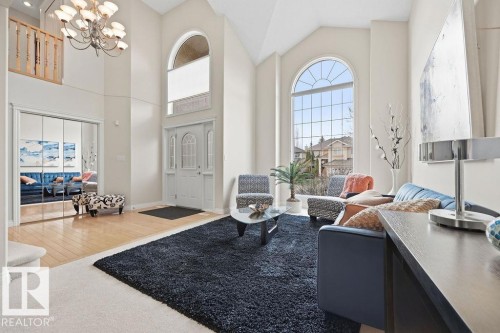 Grand entry featuring a vaulted ceiling, an arched transom window, and a chandelier - 11551 14 Avenue, Edmonton, AB - Indoor