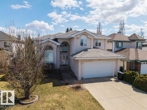Stucco exterior with arched entry, two-story window, integrated garage, and concrete driveway - 11551 14 Avenue, Edmonton, AB - Outdoor With Facade