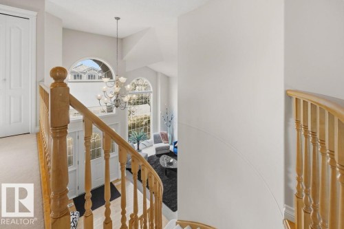 Grand foyer featuring a high ceiling, a decorative chandelier, and two large arched windows - 11551 14 Avenue, Edmonton, AB - Indoor Photo Showing Other Room