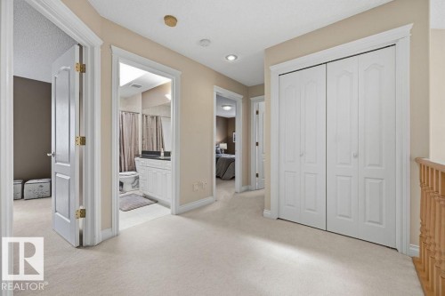 Carpeted hallway featuring white trim and doors, recessed lighting, and a bi-fold closet - 11551 14 Avenue, Edmonton, AB - Indoor