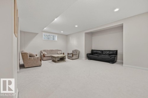 Spacious lower-level room featuring light-colored carpeting, recessed lighting, a built-in alcove, and a horizontal window - 11551 14 Avenue, Edmonton, AB - Indoor