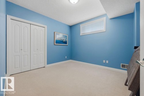 Room featuring neutral carpet flooring, blue painted walls, and white trim - 11551 14 Avenue, Edmonton, AB - Indoor Photo Showing Other Room