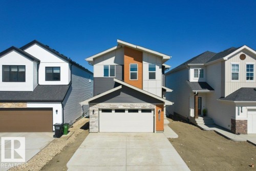 Contemporary facade featuring mixed siding, stone accents, and an integrated garage - 19110 20A Avenue, Edmonton, AB - Outdoor