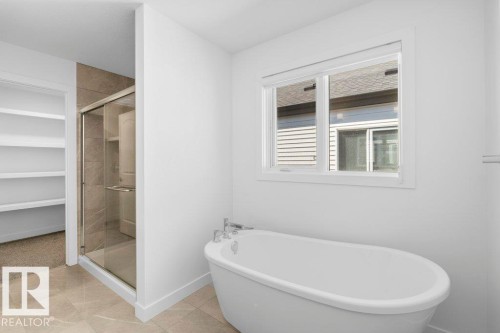 Freestanding soaking tub with chrome fixtures - 19110 20A Avenue, Edmonton, AB - Indoor Photo Showing Bathroom