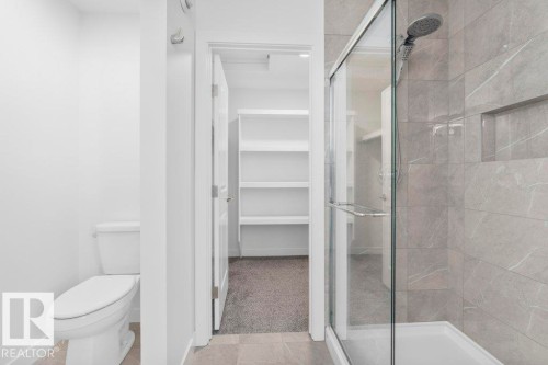 Modern bathroom featuring a glass-enclosed shower with large format tile, a built-in shower niche, and a white shower pan - 19110 20A Avenue, Edmonton, AB - Indoor Photo Showing Bathroom