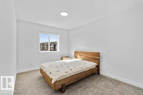 Bedroom featuring neutral carpeting, white walls, a recessed ceiling light, and a window with white blinds - 19110 20A Avenue, Edmonton, AB - Indoor Photo Showing Bedroom