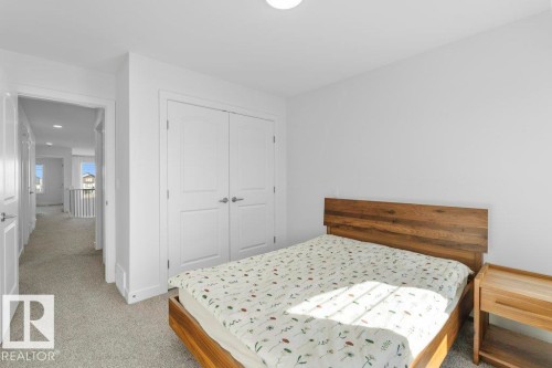Bright room with light gray carpet flooring, white walls, and a hallway entry - 19110 20A Avenue, Edmonton, AB - Indoor Photo Showing Bedroom