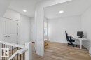 Open concept living area featuring wood-finish flooring, recessed lighting, white walls, and a white painted railing with black spindles - 19110 20A Avenue, Edmonton, AB  - Indoor 
