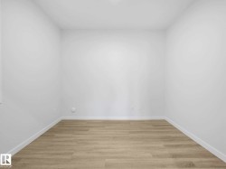 Neutral wall paint with light wood-finish flooring and white baseboards - 