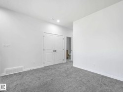 Spacious room with plush gray carpeting, crisp white walls, and a recessed ceiling light - 