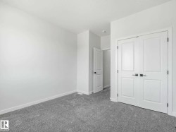 Expansive room featuring light gray carpeting and white baseboards - 