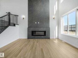 Two-story living area featuring a full-height fireplace with large format tile surround and an integrated electric firebox - 