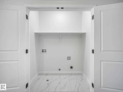 Dedicated laundry alcove featuring white paneled double doors and a built-in shelf - 