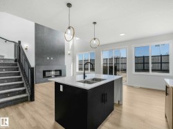 Central kitchen island with a double basin sink and a matte black faucet - 