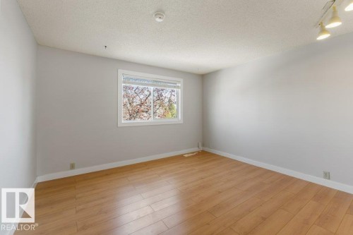 Room featuring wood-finish flooring, white baseboards, and neutral wall paint - 3736 12 Avenue, Edmonton, AB - Indoor Photo Showing Other Room