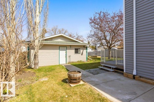 Detached garage with horizontal siding, a green roof, and a side access door, complemented by a concrete walkway - 3736 12 Avenue, Edmonton, AB - Outdoor