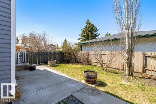 Expansive backyard featuring a concrete patio, a section of green lawn, and a wood picket fence - 3736 12 Avenue, Edmonton, AB - Outdoor
