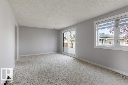 Spacious room featuring light gray walls, textured carpeting, and white trim - 3736 12 Avenue, Edmonton, AB - Indoor Photo Showing Other Room